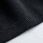Tela negra del vestido Aura, con costura visible y textura tipo sarga.