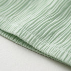 Vestido Celeste de tela verde en canalé, con costuras fruncidas y textura acanalada
