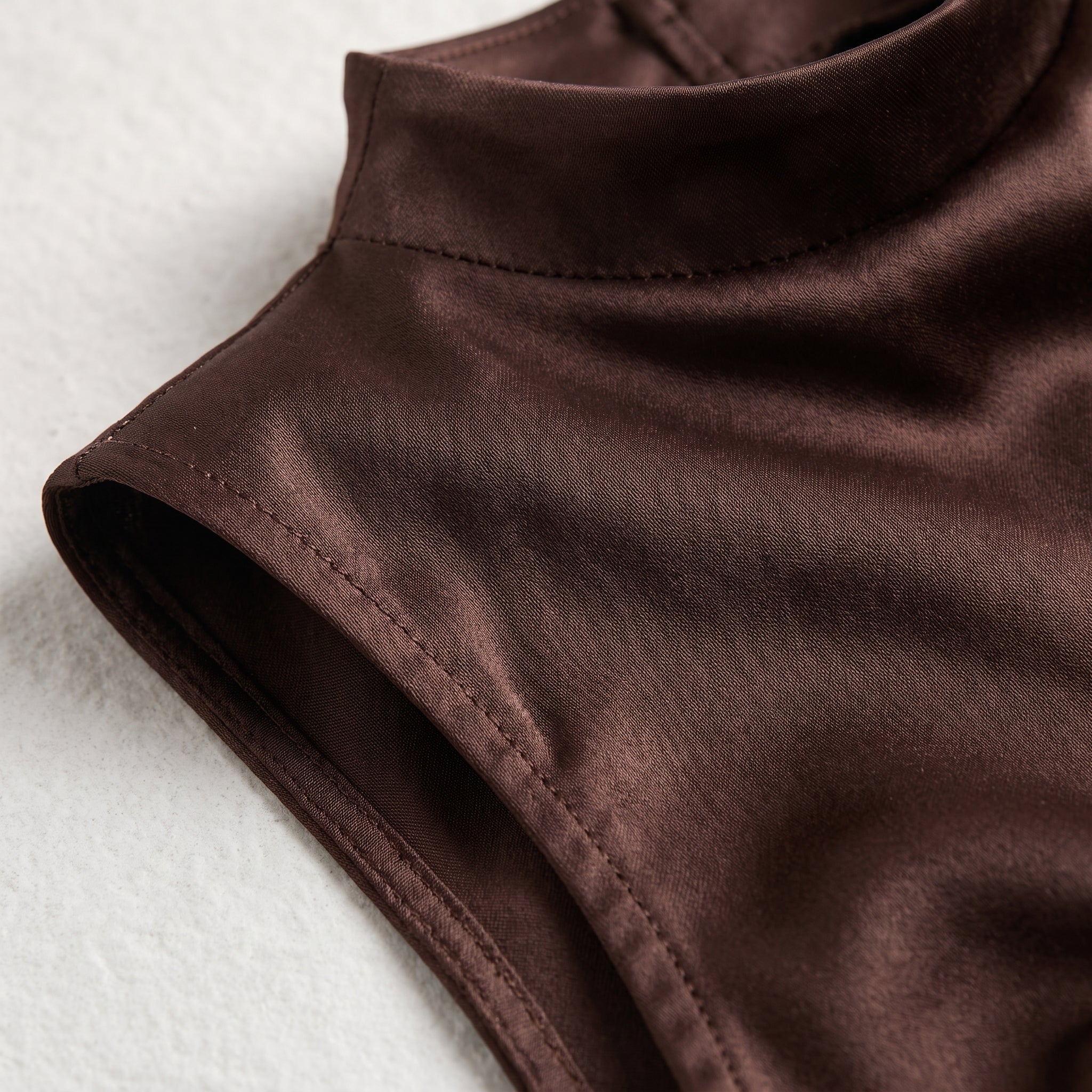 Top Carol Noir de marrón oscuro sin mangas, cuello alto y costuras visibles