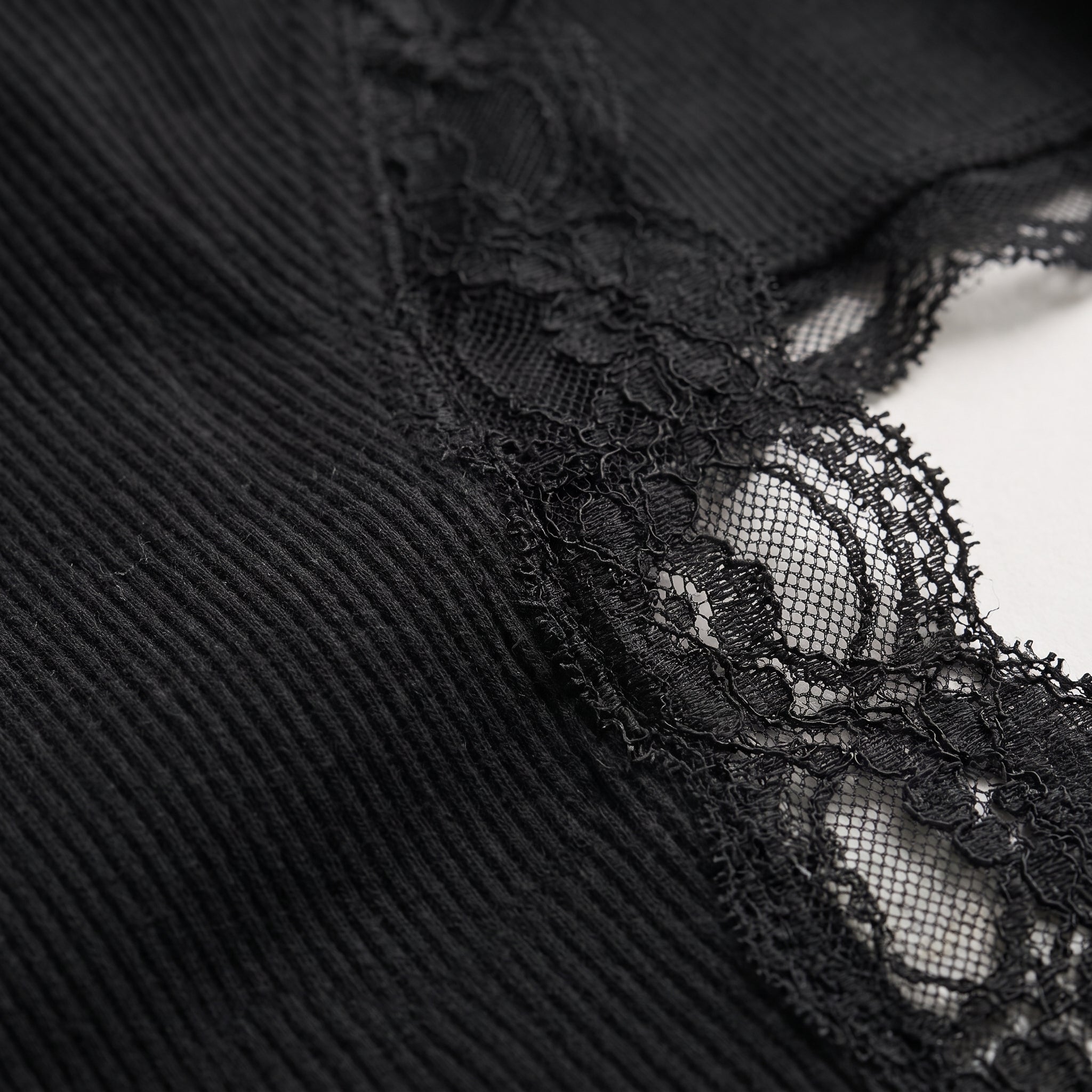 Top negro: encaje floral detallado sobre tul con textura en el tejido