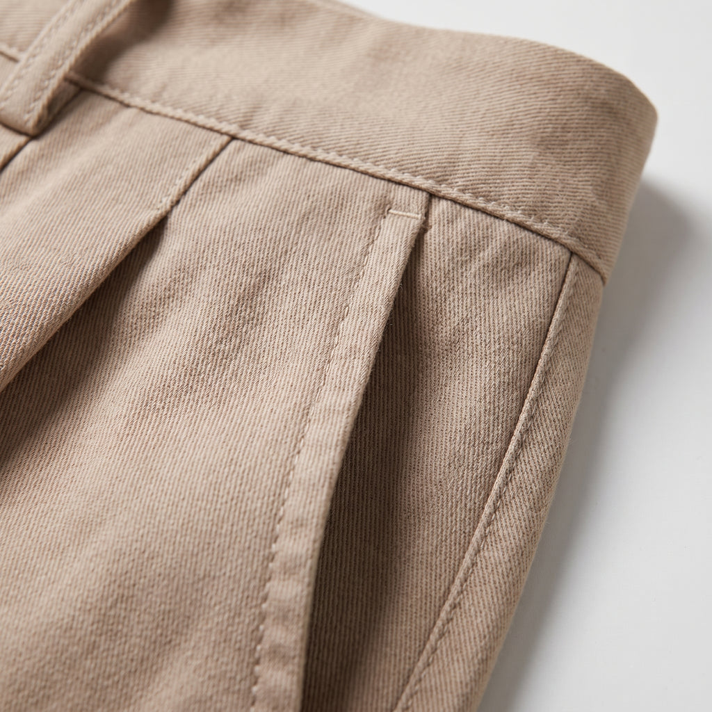 Pantalón beige: detalle de pinzas, costuras y tiro alto con trabillas.