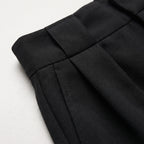 Shorts negros lisos con costuras y pinzas, vista de detalle de la tela
