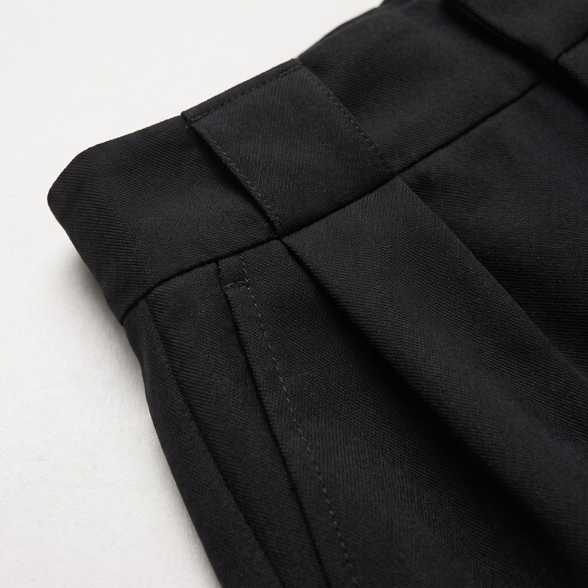Shorts negros lisos con costuras y pinzas, vista de detalle de la tela