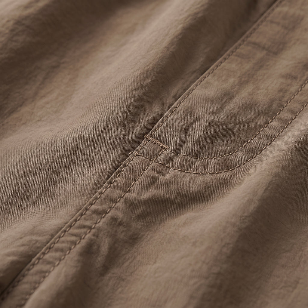 Tela del short cargo marrón con costuras y borde elástico en la cintura.