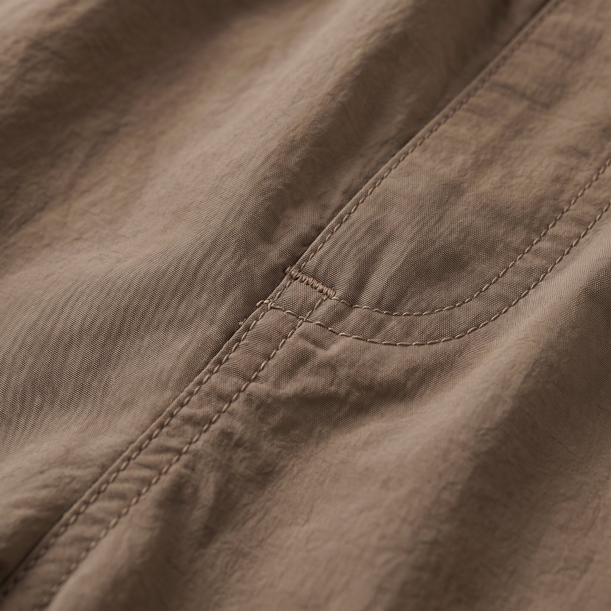 Tela del short cargo marrón con costuras y borde elástico en la cintura.
