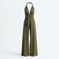 Mono verde sin mangas con cuello halter y lazo en la cintura, perneras anchas.