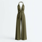 Mono verde sin mangas con cuello halter y lazo en la cintura, perneras anchas.
