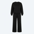 Conjunto de suéter y pantalón negro con brillo sutil; pantalón ancho con cordón.