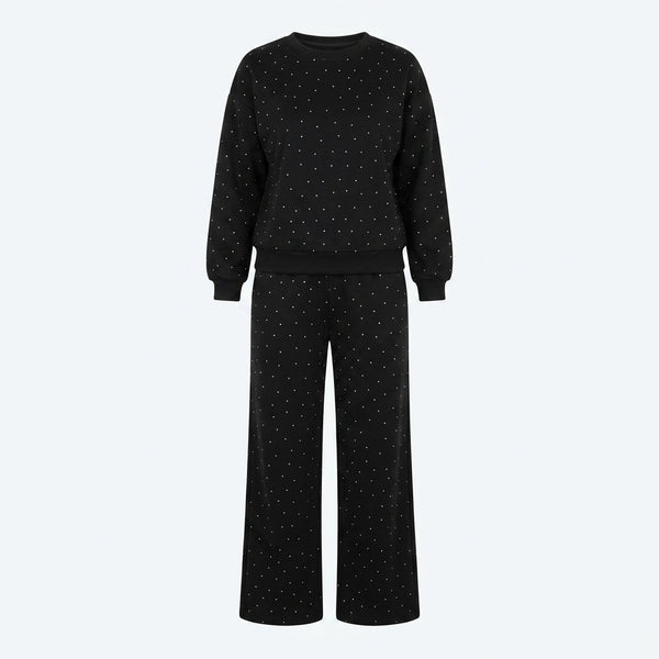 Conjunto de suéter y pantalón negro con brillo sutil; pantalón ancho con cordón.