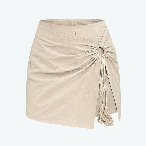 Falda corta beige con frunce lateral y cordón con flecos