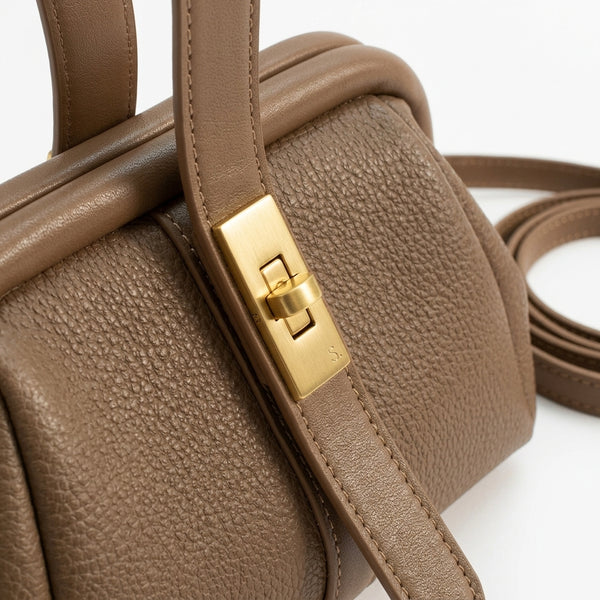 Bolso de piel texturizada con cierre metálico dorado en la solapa