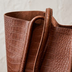 Bolso maxi vintage marrón oscuro con textura de cocodrilo y asas dobles.
