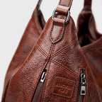 Bolso Orinethe de cuero marrón texturizado con parche frontal y tiradores de cremallera
