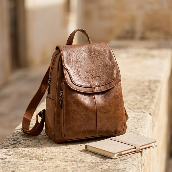 Mochila de cuero marrón con solapa frontal, bolsillo lateral con cremallera y asa