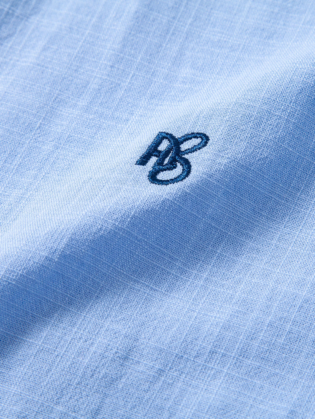 Camisa Capri celeste: detalle del logotipo bordado en el pecho