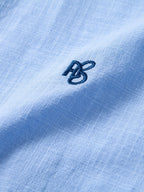Camisa Capri celeste: detalle del logotipo bordado en el pecho