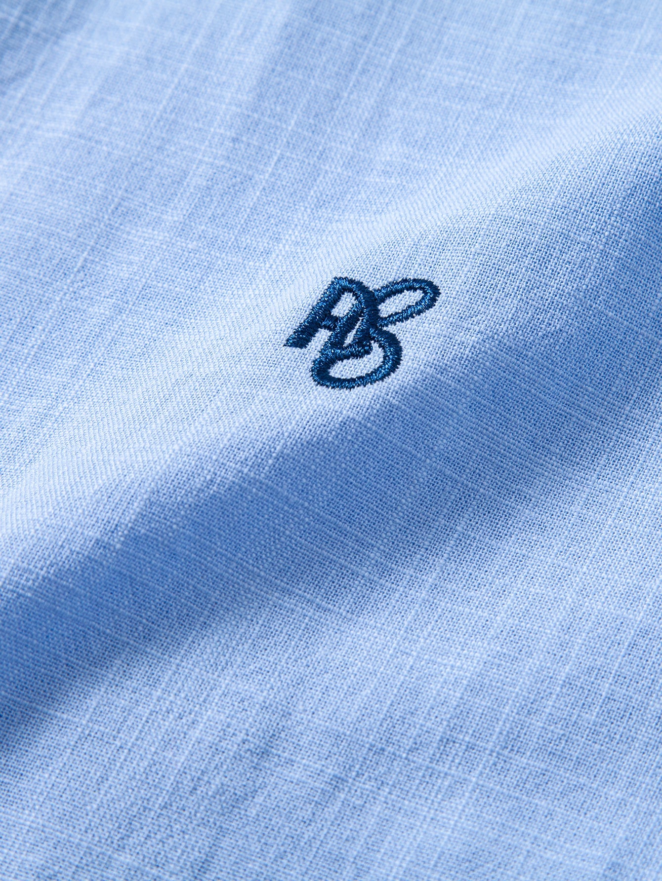 Camisa Capri celeste: detalle del logotipo bordado en el pecho