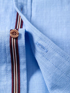 Camisa capri azul claro con tapeta a rayas y costuras en el cuello