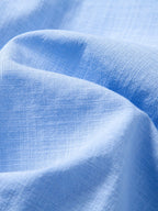Camisa capri azul claro de tela con textura lisa, sin logos visibles