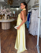 Vestido largo amarillo sin mangas con cuello alto halter y falda con abertura