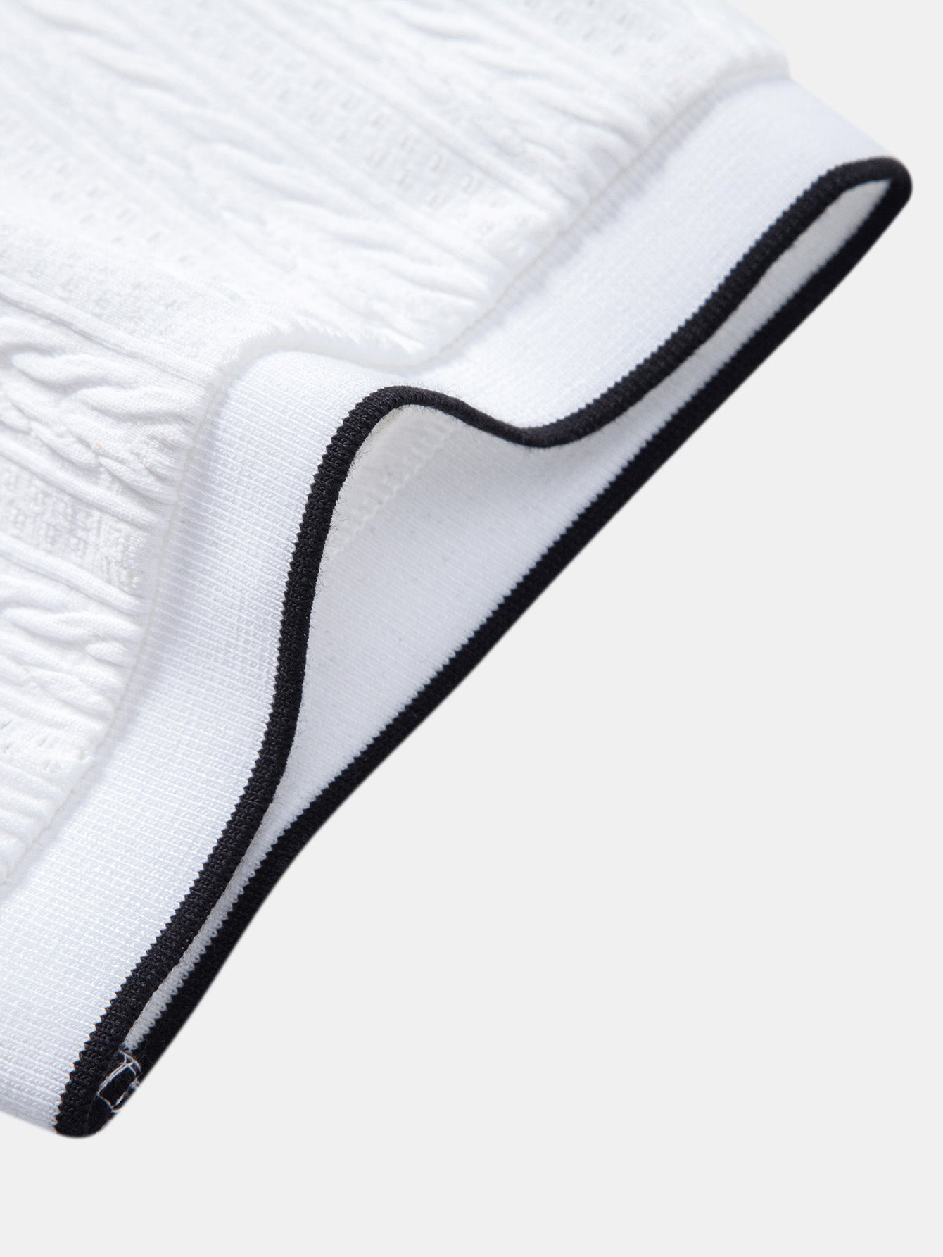 Polo blanco de piqué con terminación del cuello y borde negro curvado