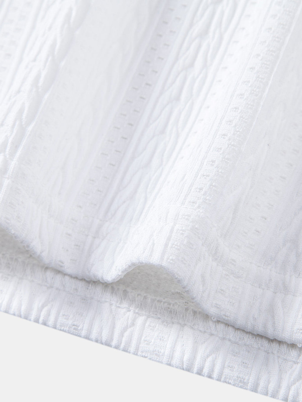 Bajo del polo blanco de piqué con borde acanalado y frunces