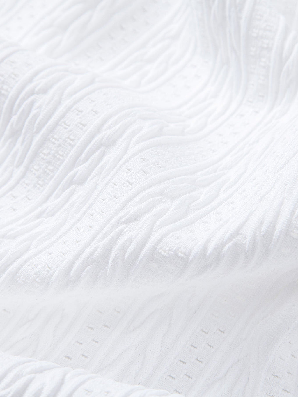 Tejido piqué del polo blanco con textura en relieve y pequeñas marcas
