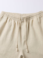 Pantalón corto de lino beige, cintura elástica y cordón anudado, vista frontal.