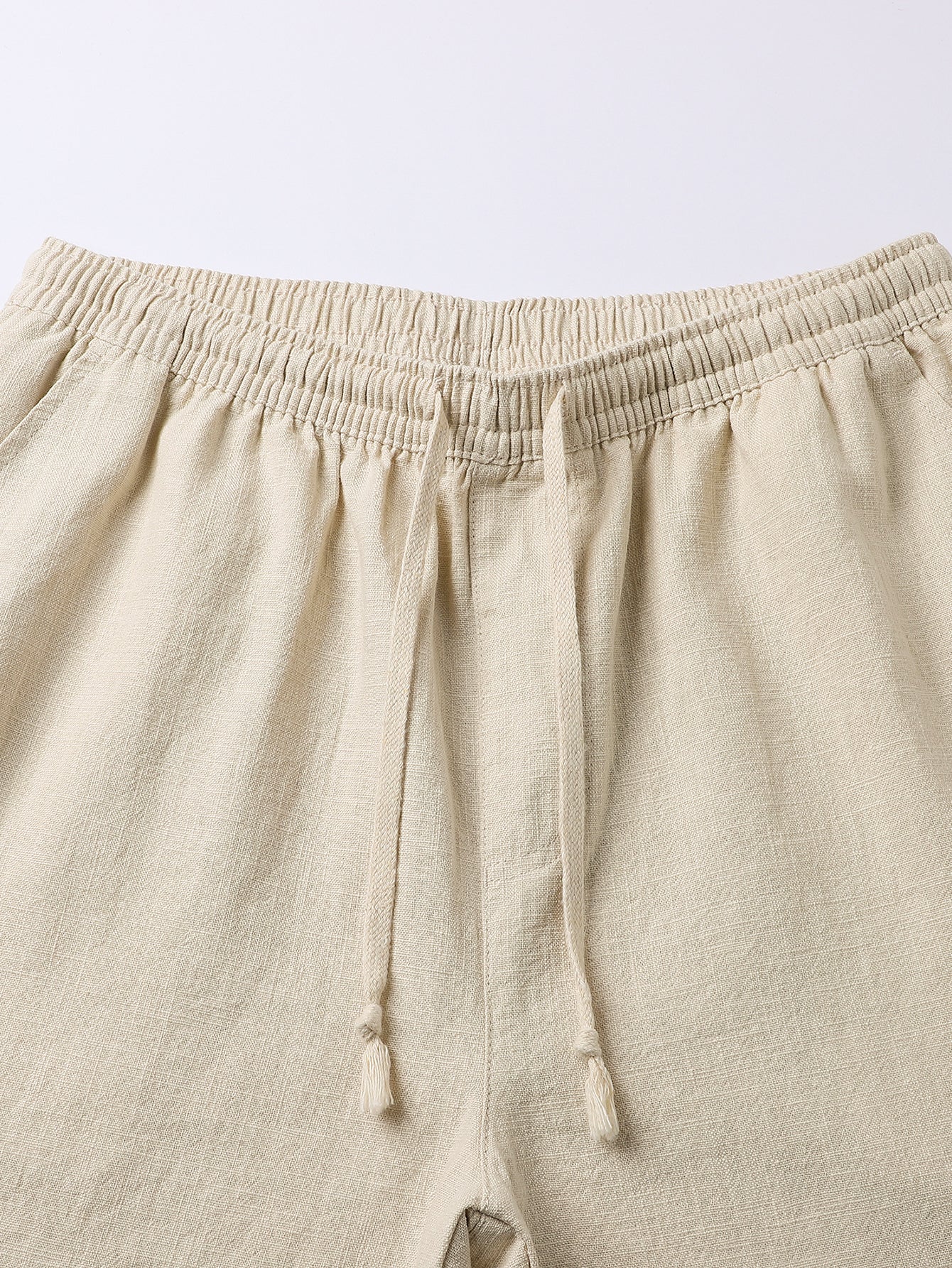Pantalón corto de lino beige, cintura elástica y cordón anudado, vista frontal.
