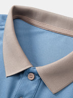 Detalle de cuello y tapeta: polo azul claro con ribete beige y botón
