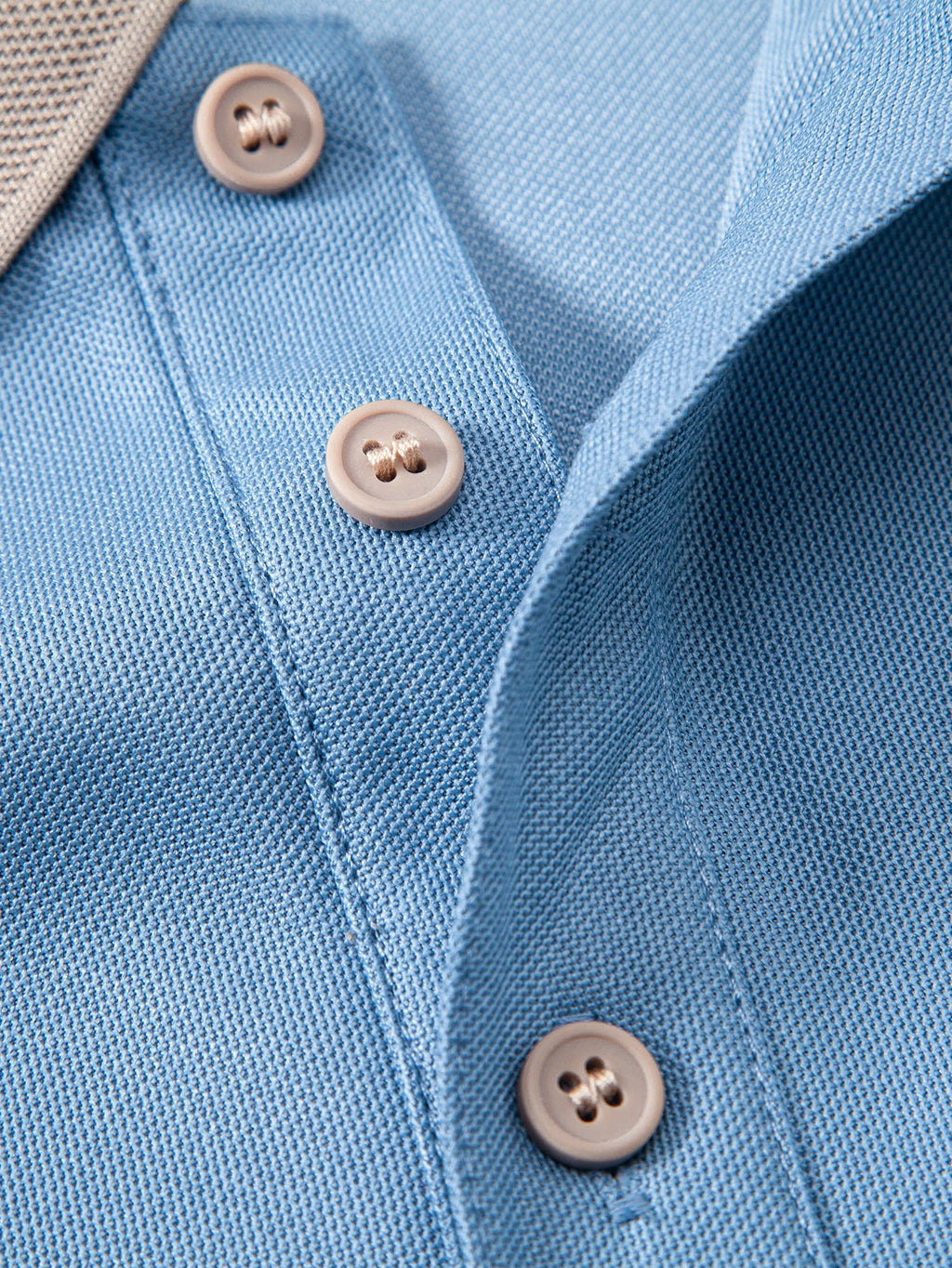 Polo azul claro con tapeta y tres botones al frente