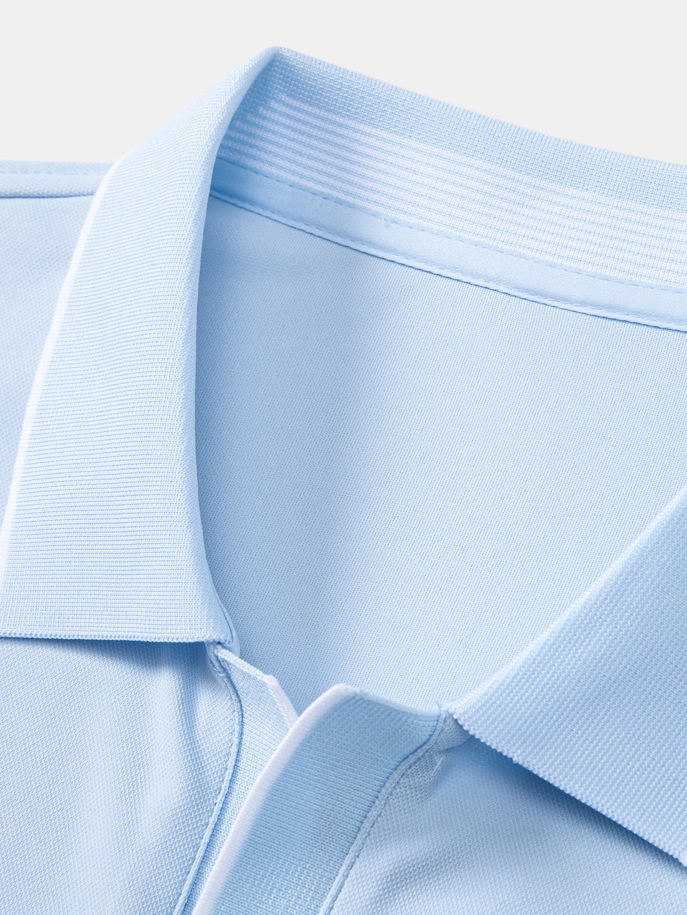 Polo celeste: cuello acanalado y tapeta con botones, vista de detalle.