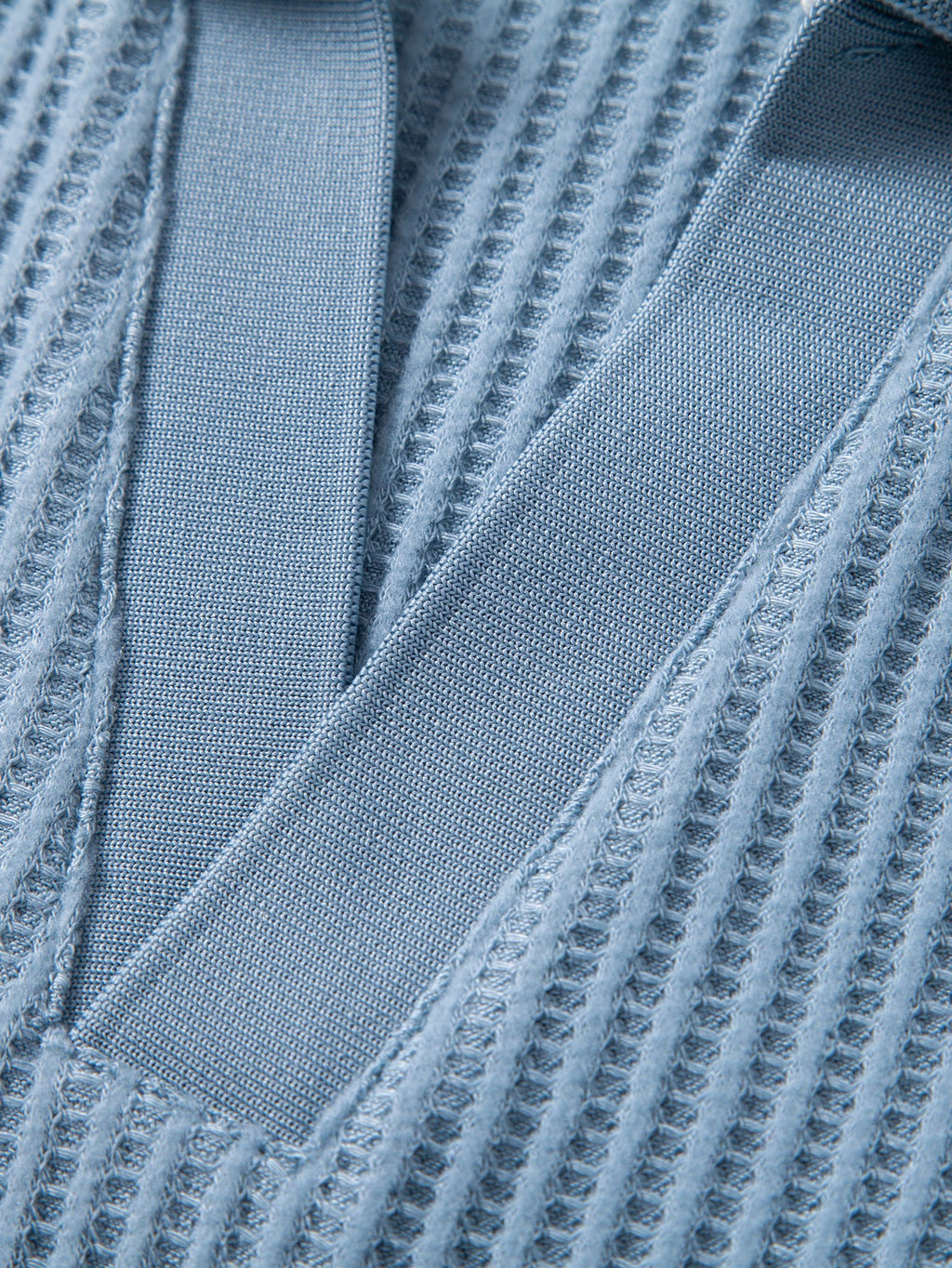 Detalle frontal de pantalones cortos de punto celestes con costuras