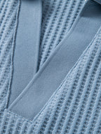 Detalle frontal de pantalones cortos de punto celestes con costuras