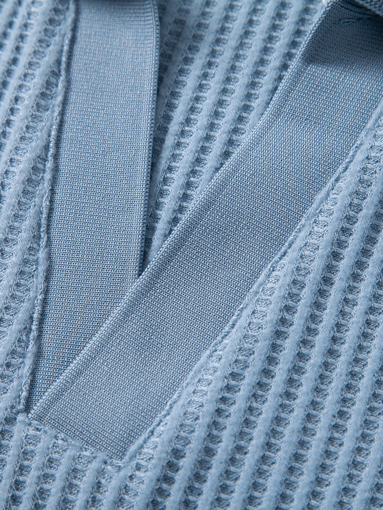 Detalle frontal de pantalones cortos de punto celestes con costuras
