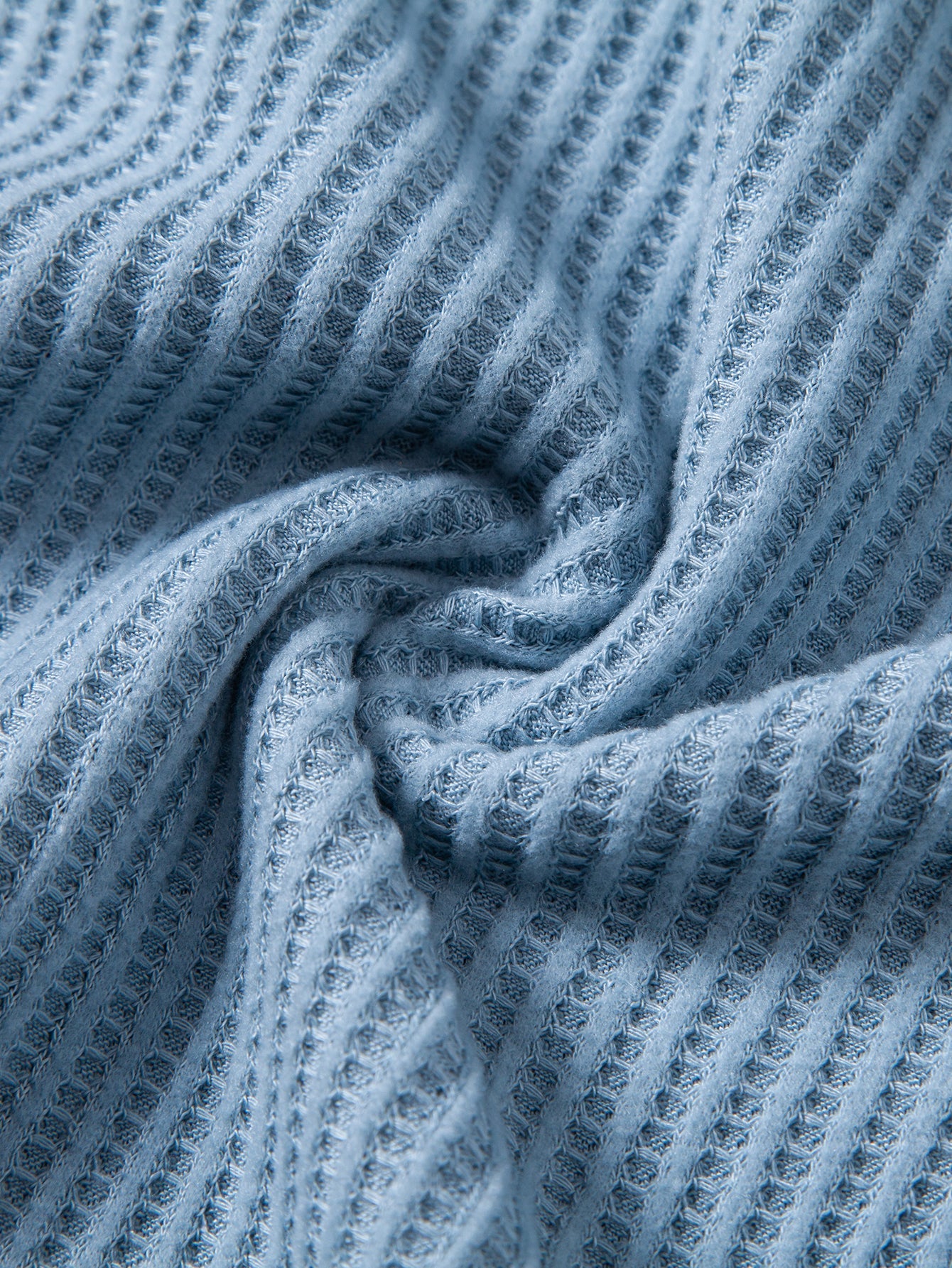 Textura del tejido piqué de los pantalones cortos de punto celestes