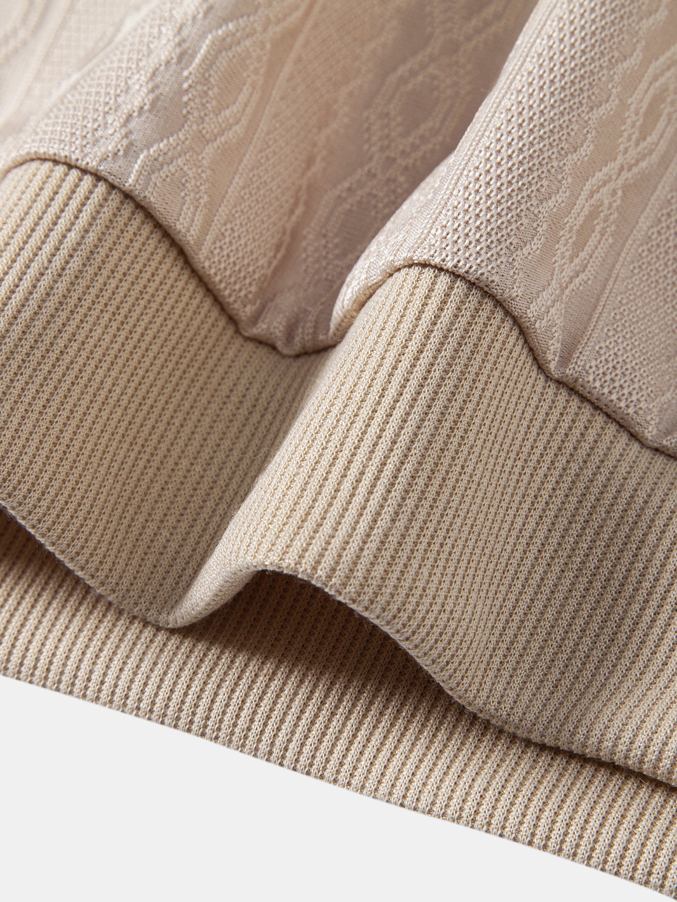 Polo beige de punto con ribetes marrones en la tapeta y cuello