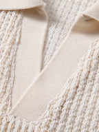Detalle del polo beige con solapa en V y textura de punto calado