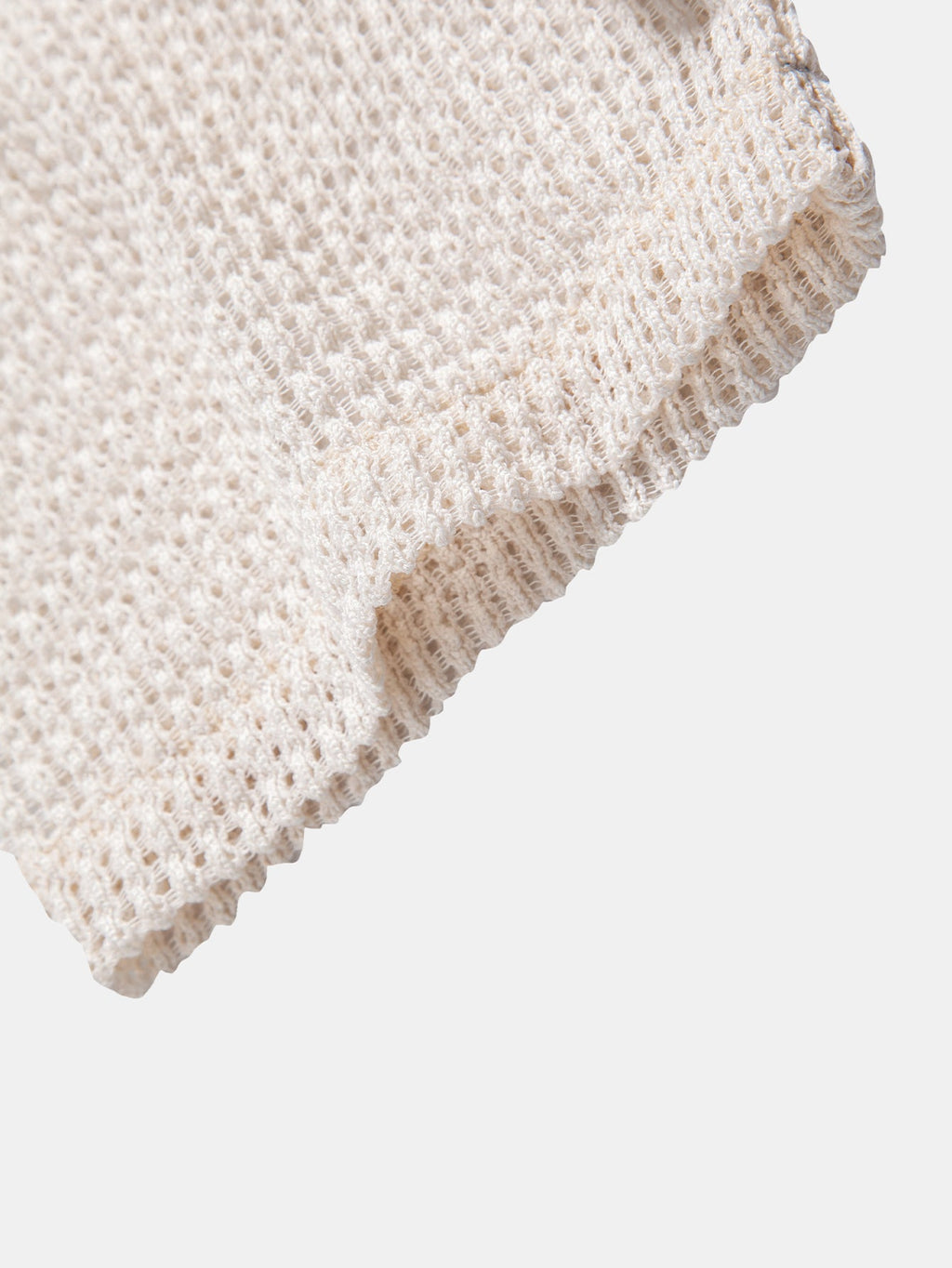 Bajo del polo beige de punto calado con remate tejido y borde vuelto