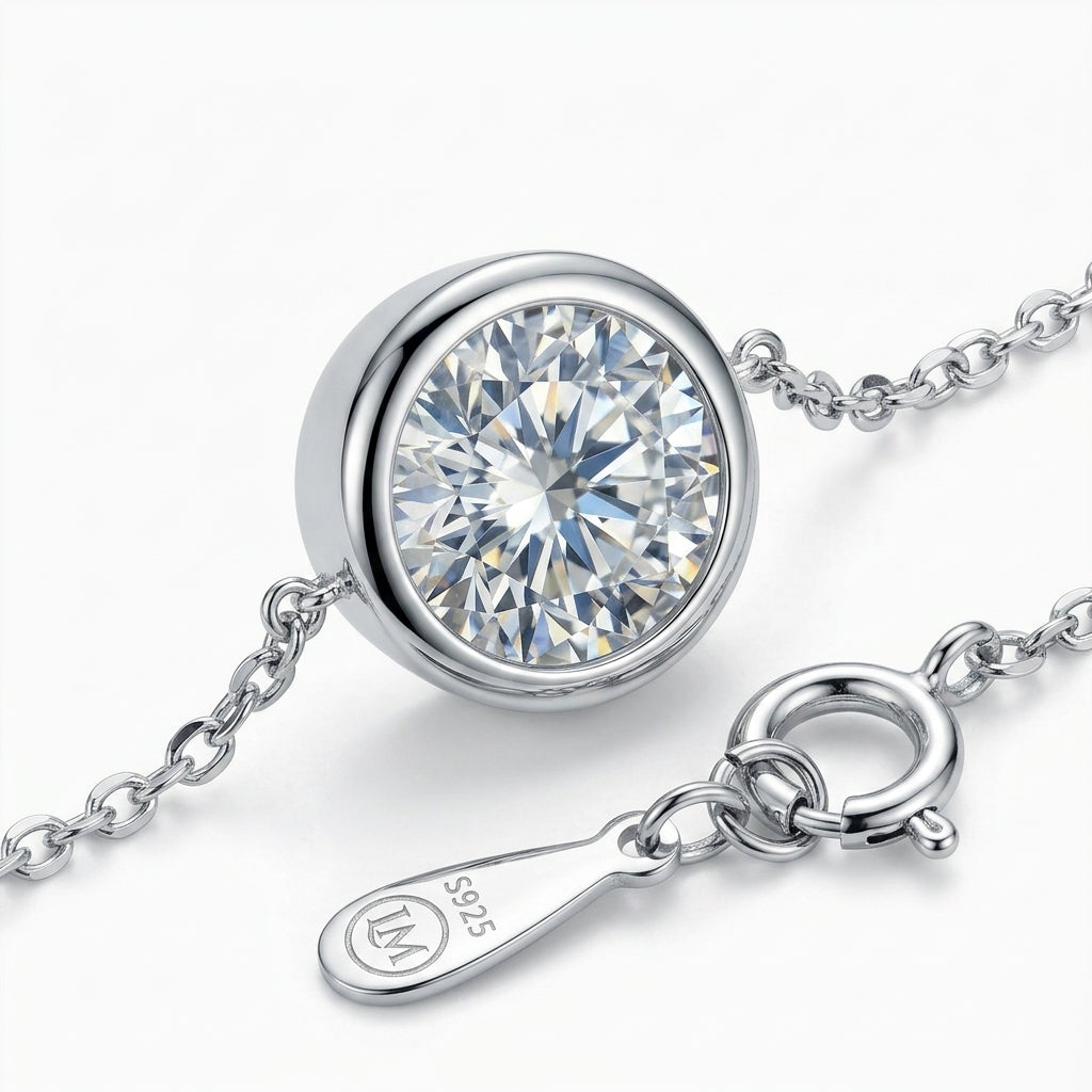 Pulsera de plata con dije circular y piedra transparente talla solitario.
