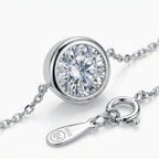Pulsera de plata con dije circular y piedra transparente talla solitario.