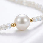 Collar de perlas blancas con perla grande central y cuentas esféricas doradas
