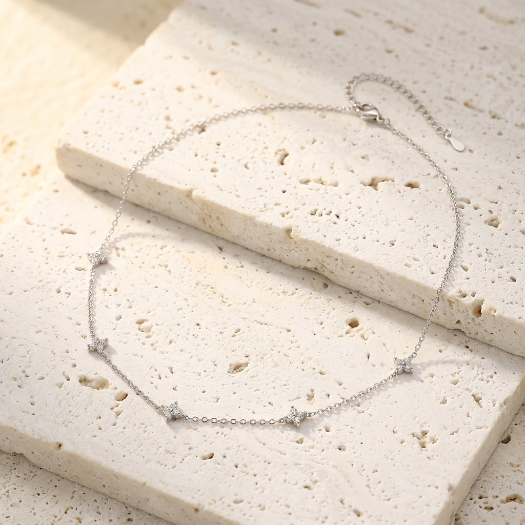 Collar plateado con cadena fina y colgantes de estrella con circonitas