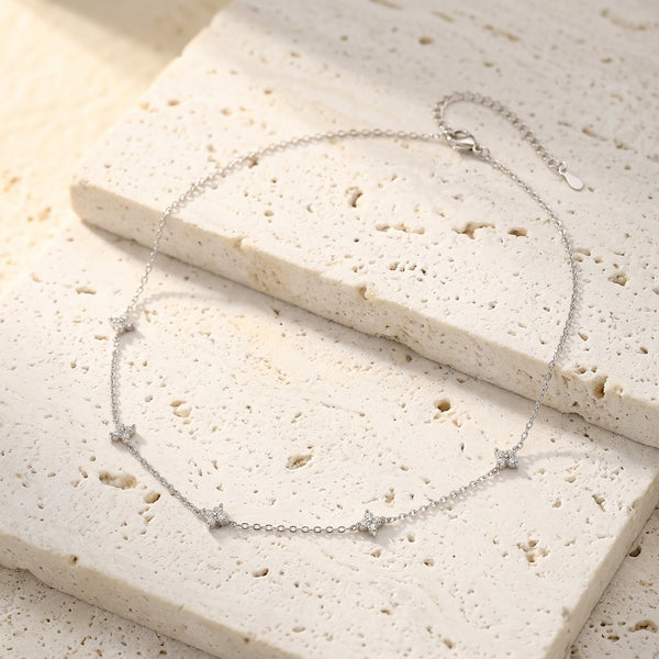 Collar plateado con cadena fina y colgantes de estrella con circonitas