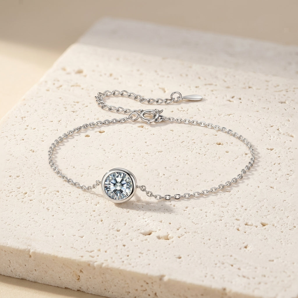 Pulsera de plata con piedra central redonda transparente en bisel.