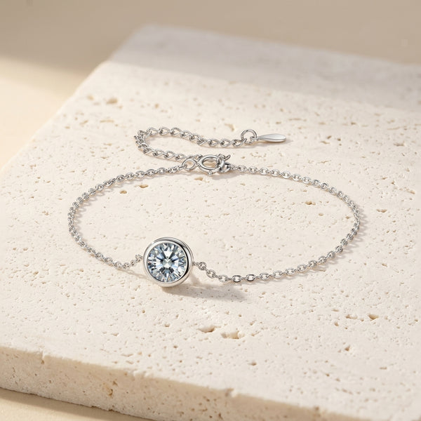 Pulsera de plata con piedra central redonda transparente en bisel.