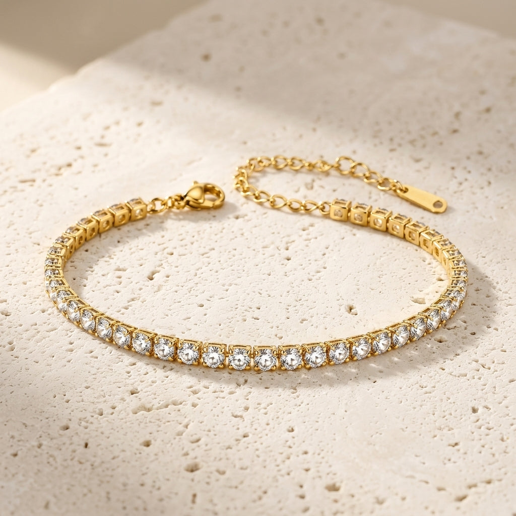 Pulsera dorada con fila de cristales brillantes y cierre tipo mosquetón.