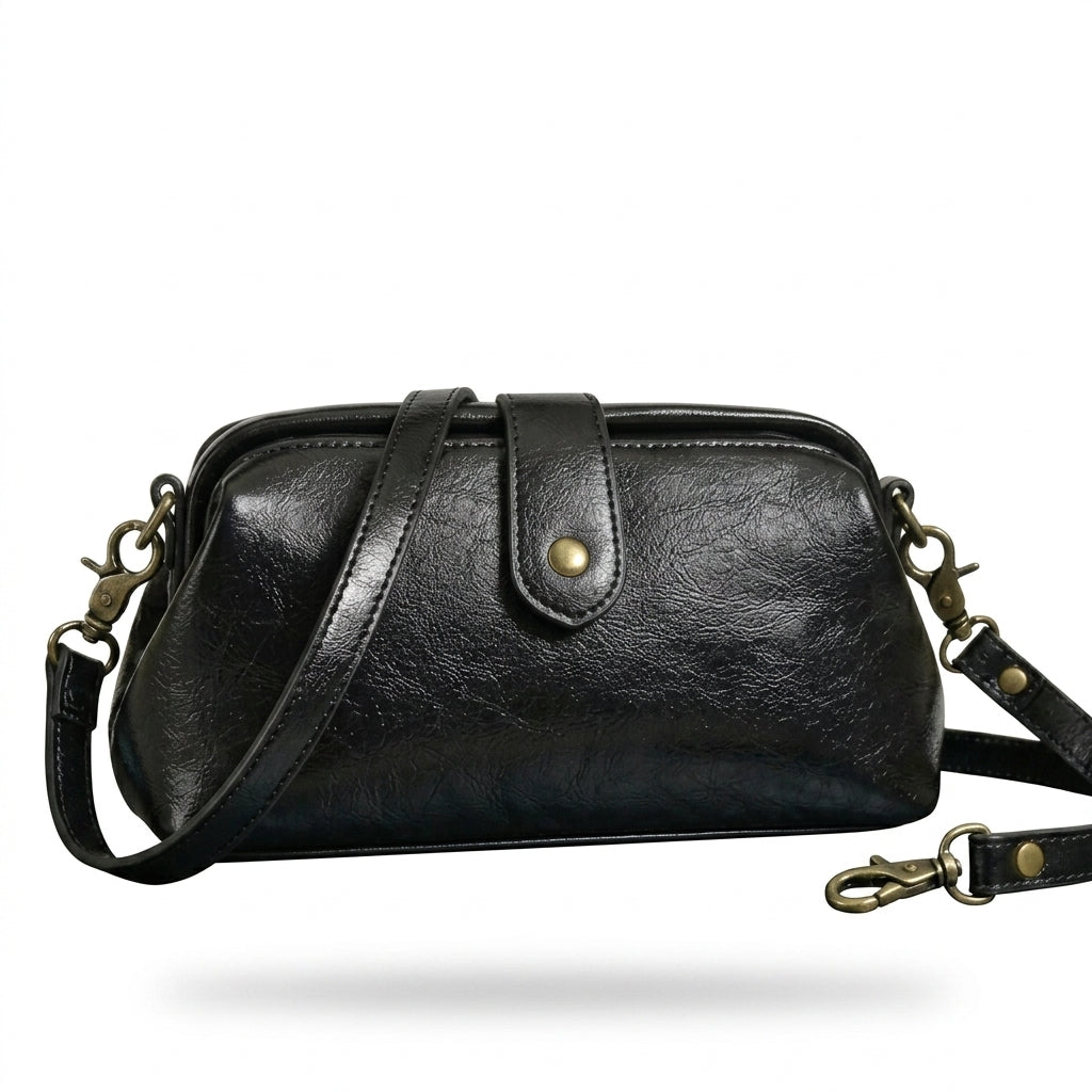 Bolso bandolera vintage de cuero negro con asa superior y correa ajustable, herrajes dorados