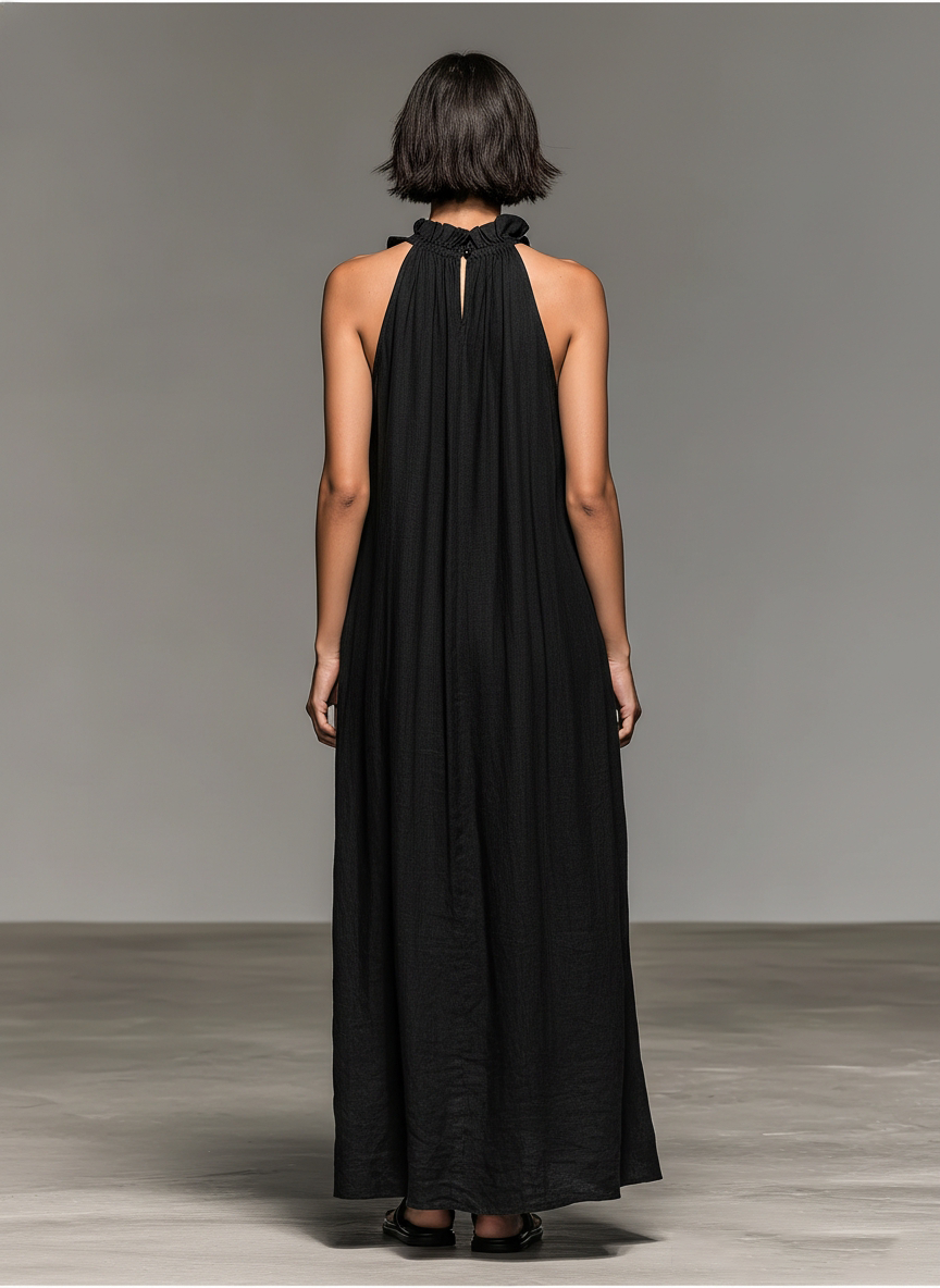 Vestido largo de lino negro con espalda descubierta y cuello alto con lazo, sin mangas.