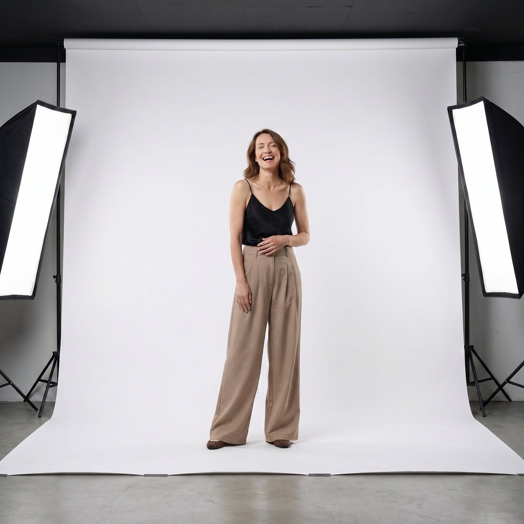 Pantalón beige de tiro alto con pinzas y pernera ancha; modelo con caída recta.